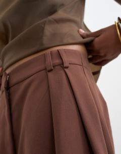 Model wearing Tailored barrel leg tab detail trouser in brown