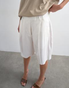 Model wearing Tailored linen blend ovoid bermuda shorts in ecru