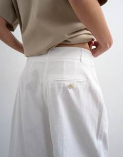 Model wearing Tailored linen blend ovoid bermuda shorts in ecru