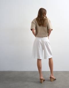 Model wearing Tailored linen blend ovoid bermuda shorts in ecru
