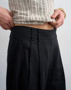 Model wearing Tailored linen ovoid bermuda shorts in black