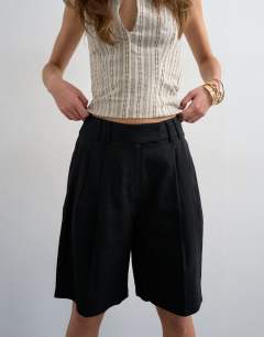 Model wearing Tailored linen ovoid bermuda shorts in black
