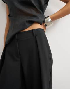 Model wearing Tailored pleat detail low rise wide leg trousers in black