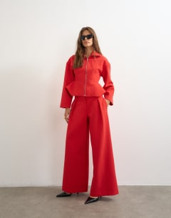 Model wearing Tailored pleat detail low rise wide leg trousers in red