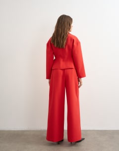 Model wearing Tailored pleat detail low rise wide leg trousers in red