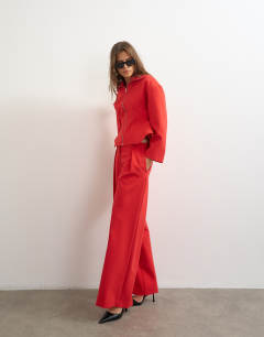 Model wearing Tailored pleat detail low rise wide leg trousers in red