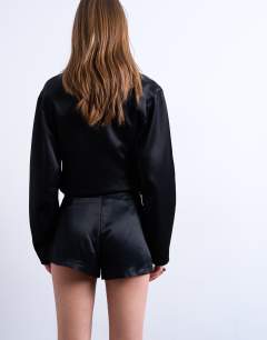 Model wearing Tailored satin micro short in black