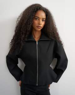 Model wearing Tailored zip through peplum top in black