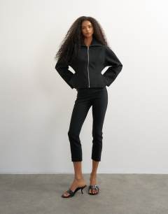 Model wearing Tailored zip through peplum top in black