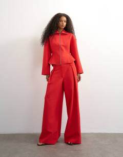 Model wearing Tailored zip through peplum top in red