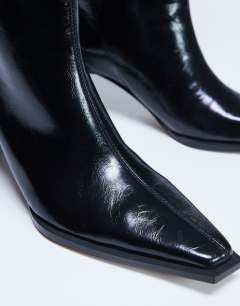 Model wearing Talia chisel toe knee high boot in black
