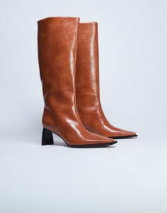 Model wearing Talia chisel toe knee high boot in tan