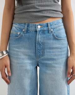 Model wearing Tall Cinch low rise relaxed jean in bleach