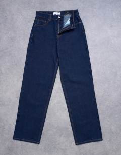 Model wearing Tall Cinch low rise relaxed jean in raw look indigo