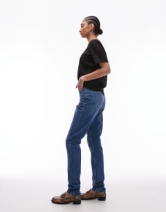 Model wearing Tall Mom high rise jean in mid blue