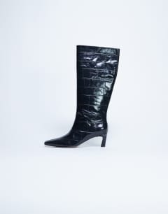 Model wearing Tanya point toe knee high boot in black croc