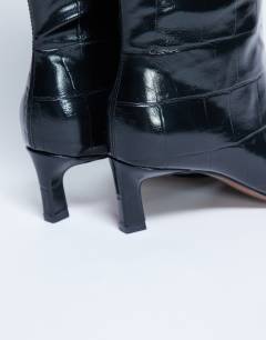 Model wearing Tanya point toe knee high boot in black croc