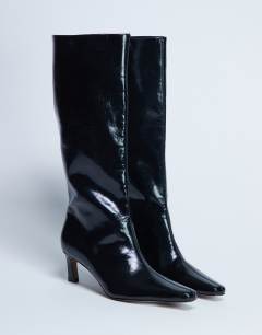 Model wearing Tanya point toe knee high boot in black