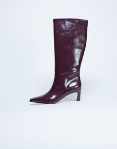 Model wearing Tanya point toe knee high boot in burgundy
