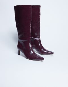 Model wearing Tanya point toe knee high boot in burgundy