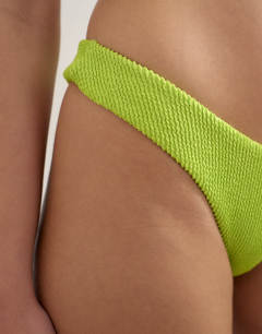 Model wearing Tara crinkle high leg cheeky bikini bottom in lime