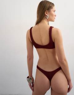 Model wearing Tara crinkle scoop bikini top in aubergine