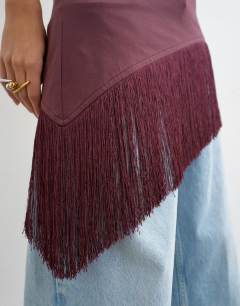 Model wearing Tassel hem asymmetric top in plum