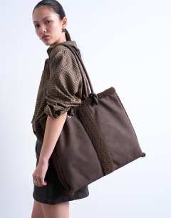 Model wearing Tate shearling tote bag in chocolate