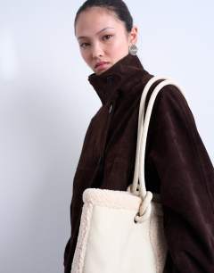 Model wearing Tate shearling tote bag in off white