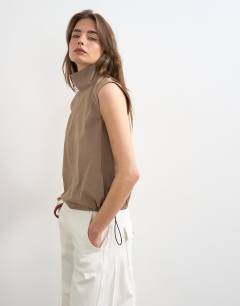 Model wearing Techy funnel drawstring hem top in mocha