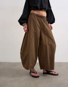 Model wearing Techy oversized ovoid mid length trouser in chocolate