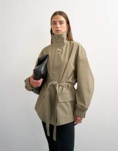Model wearing Techy tie waist funnel neck jacket in neutral