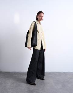 Model wearing Teegan hair on real leather oversize weave tote in chocolate