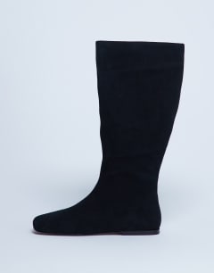 Model wearing Tess real suede knee high flat boot in black