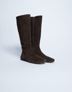 Model wearing Tess real suede knee high flat boot in chocolate