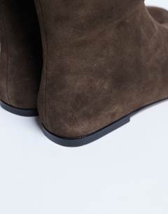 Model wearing Tess real suede knee high flat boot in chocolate