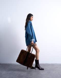 Model wearing Teven faux fur tote bag in brown
