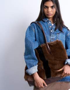 Model wearing Teven faux fur tote bag in brown