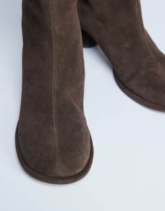 Model wearing Thea real suede knee high block heel boot in chocolate