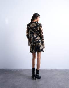 Model wearing Tie front long sleeve mini tea dress in abstract print