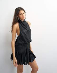 Model wearing Tie neck halter flippy mini dress with embroidered detail in black