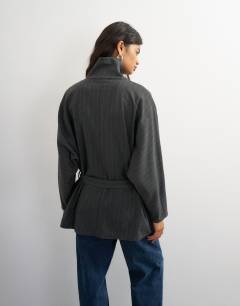 Model wearing Tie waist funnel neck shirt in grey pinstripe