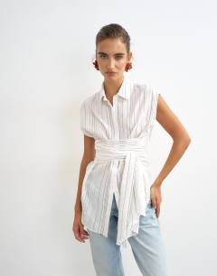 Model wearing Tie waist sleeveless shirt in white stripe
