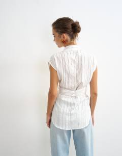 Model wearing Tie waist sleeveless shirt in white stripe