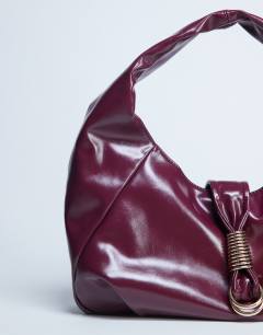 Model wearing Tilly metal hardware slouchy tote bag in burgundy