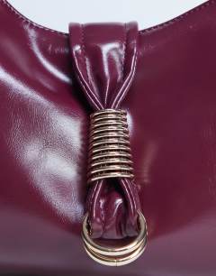 Model wearing Tilly metal hardware slouchy tote bag in burgundy