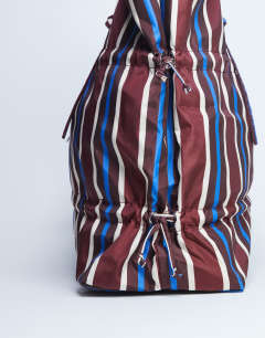 Model wearing Tino nylon ruched tote bag in burgundy stripe