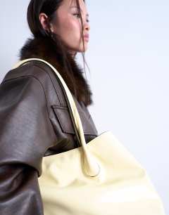 Model wearing Toby tubler handle tote bag in buttermilk