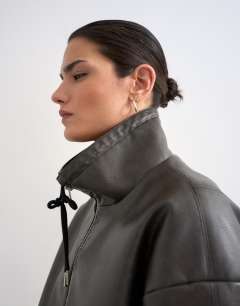 Model wearing Toggle waist leather look funnel zip through jacket in black
