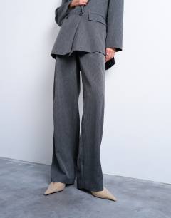 Model wearing Tonic pleated suit trouser with side buckle in grey